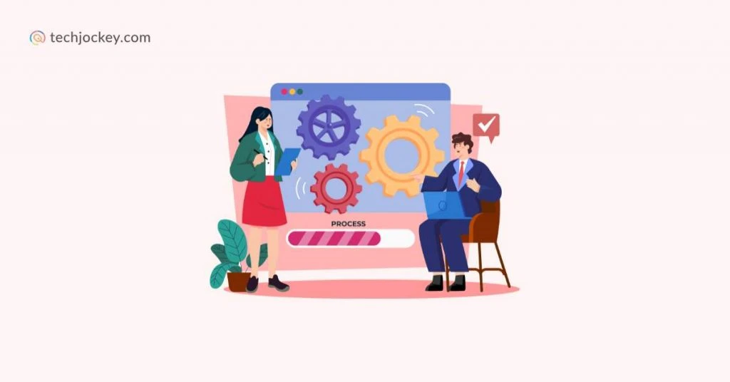 Illustration of a woman and man discussing in front of a large process screen with three animated gears, a progress bar, a plant, and a techjockey.com logo in the corner.