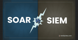 An infographic divided into two halves comparing SOAR and SIEM, with SOAR written in large white text on a blue background on the left, SIEM in large white text on a brown background on the right, and a lightning bolt shape at the center displaying the letters VS, along with the techjockey.com logo in the bottom right corner.