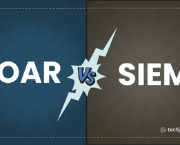 An infographic divided into two halves comparing SOAR and SIEM, with SOAR written in large white text on a blue background on the left, SIEM in large white text on a brown background on the right, and a lightning bolt shape at the center displaying the letters VS, along with the techjockey.com logo in the bottom right corner.