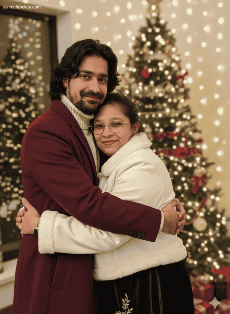 Couple embracing and smiling in front of a beautifully lit Christmas tree with festive decorations in a warm holiday setting.
