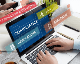 Best HR compliance software dashboard showing compliance, regulations, law, and standards on a laptop used by HR professionals in an office setting.