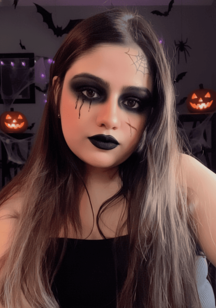 Person takes a selfie featuring horror makeup and a sly, chilling expression under dim lighting